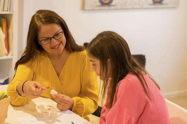 Sim and a student working together with letter blocks